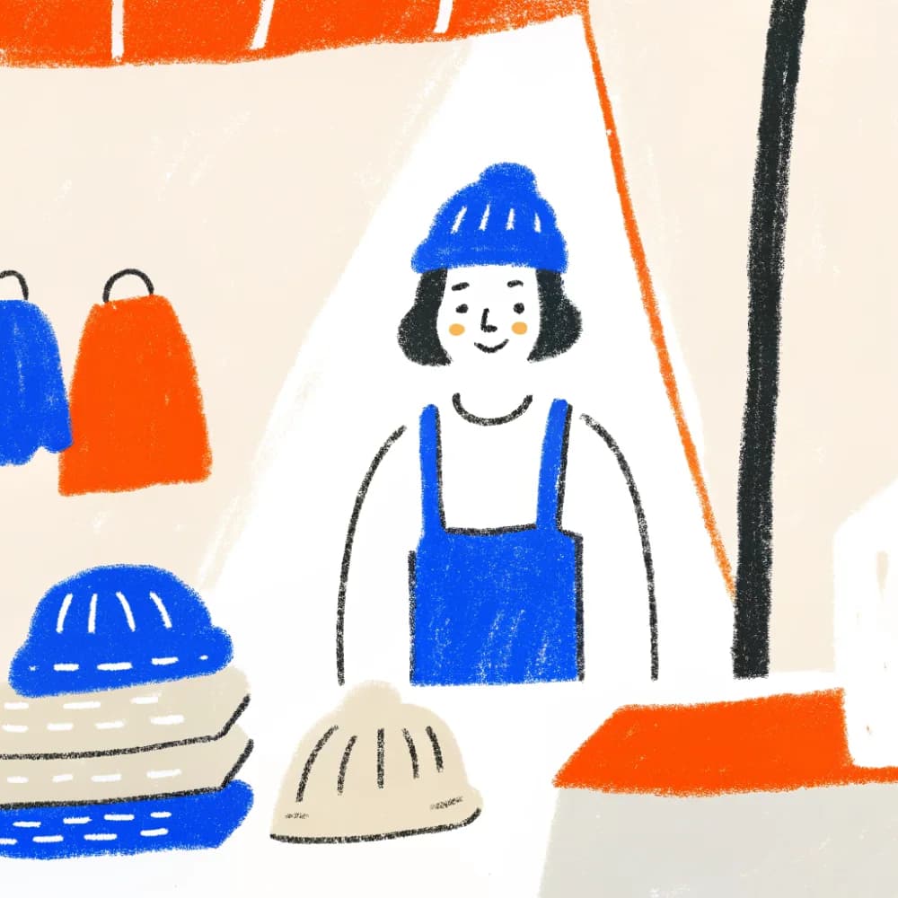 A friendly small maker at a market stall of handmade goods